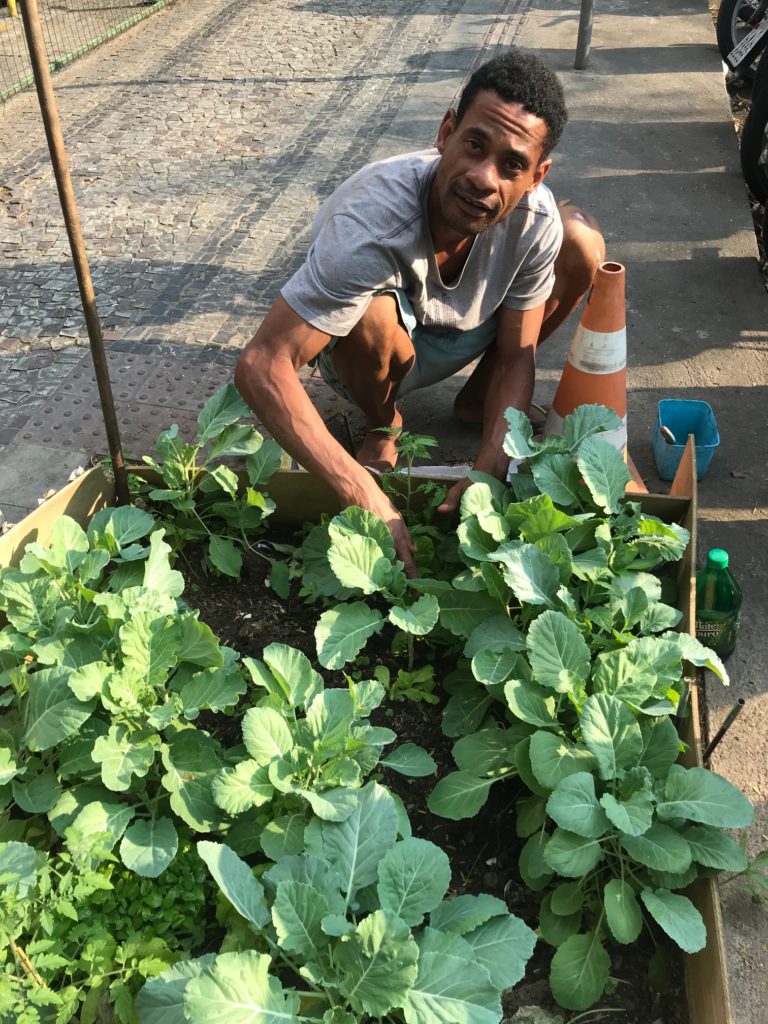 Wellington Damião, lavador de carro, cuidando de sua mini-horta na rua de um bairro nobre de Belo Horizonte.